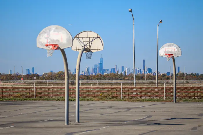 a basketball court with the Manhattan skyline in the distance
